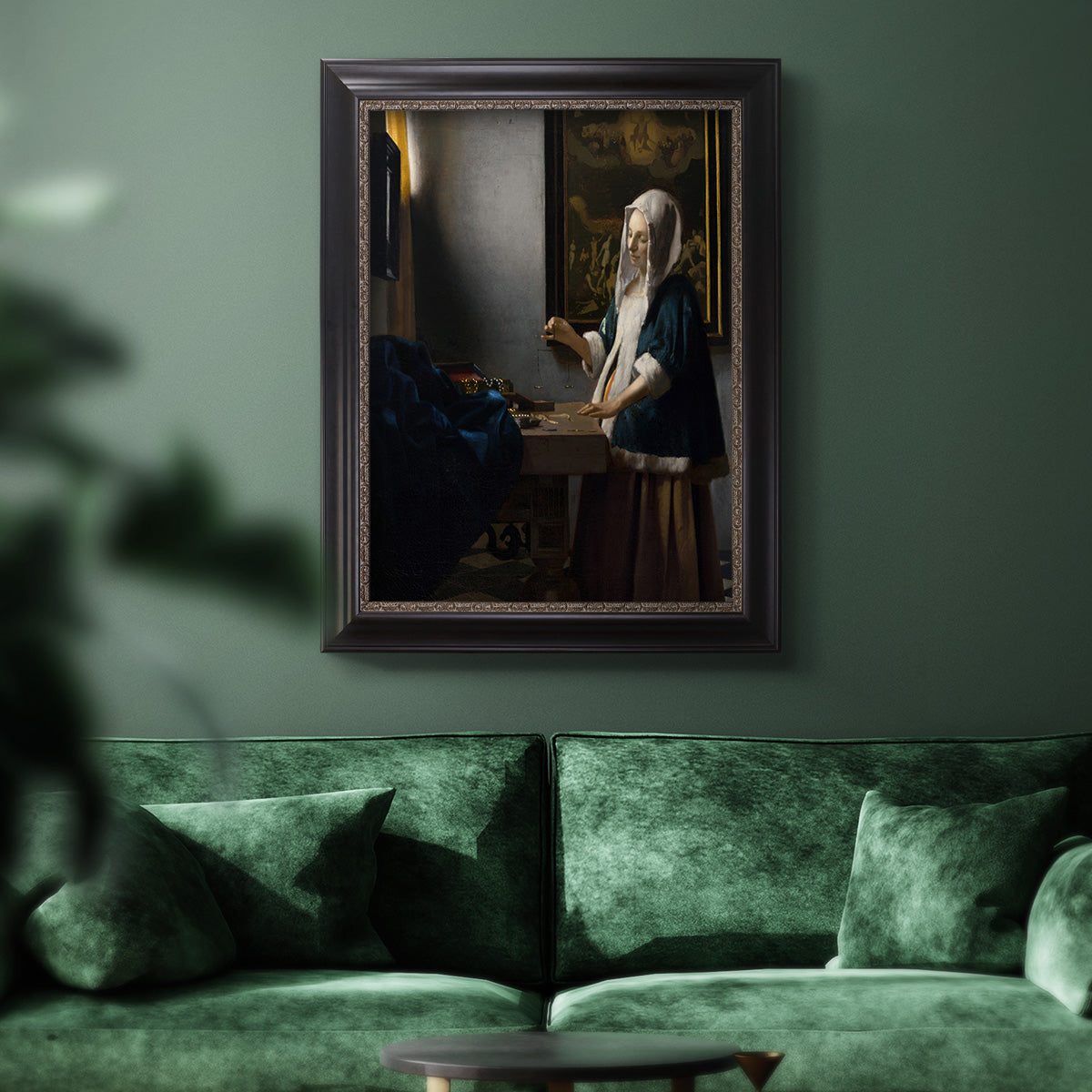 Quiet interior genre scene of a woman with scales by Johannes Vermeer in an ornate black frame with gilded inner detail displayed in a dark-toned interior setting.