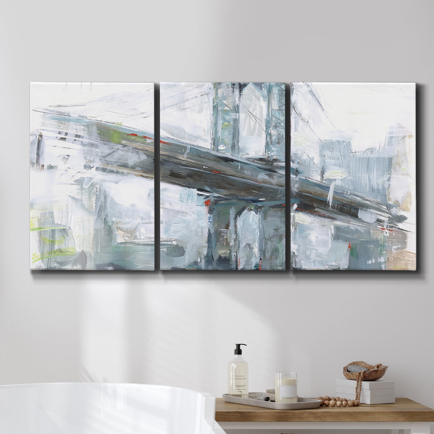 Three-panel canvas wall art featuring urban cityscape with architectural forms, displayed in a bathroom above a bathtub.
