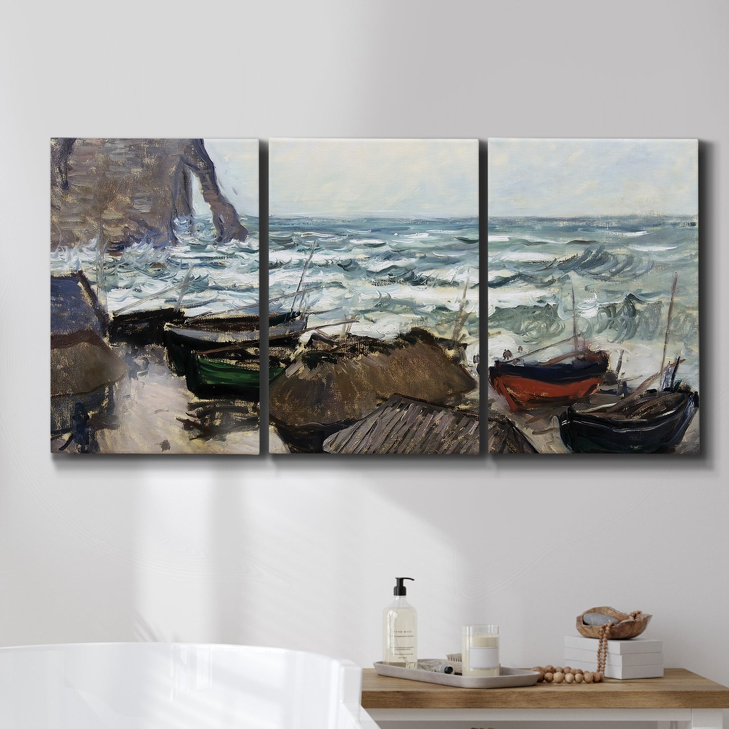 Three-panel canvas wall art featuring rough coastal seas under storm clouds, displayed in a bathroom above a bathtub.