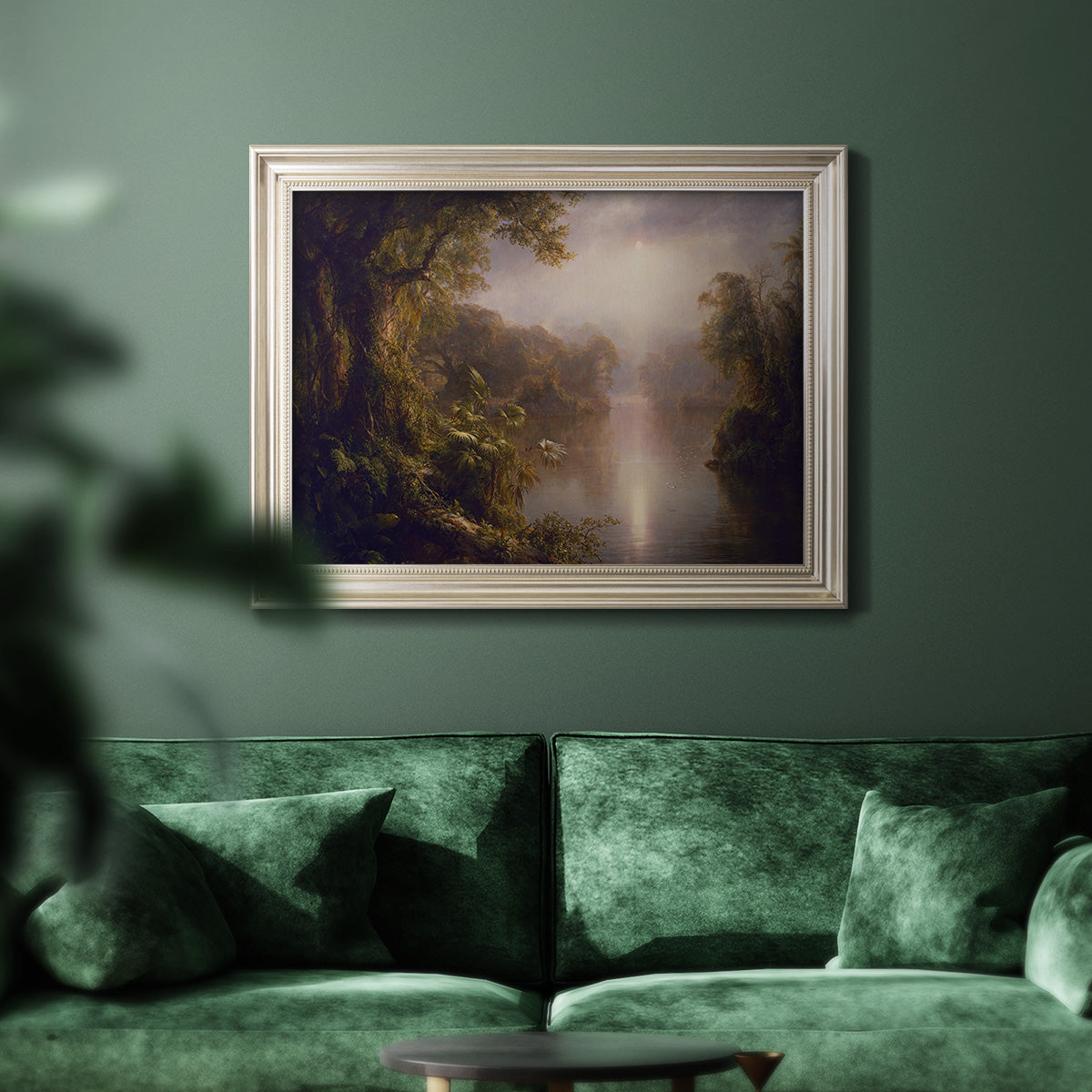 Luminous romantic landscape painting by Frederic Edwin Church in an ornate champagne frame displayed in a dark-toned interior setting.