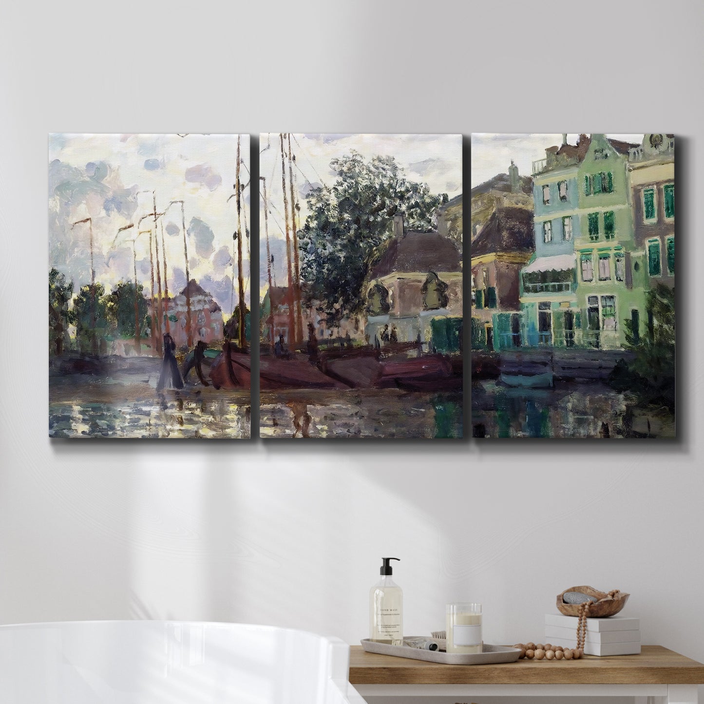 Three-panel canvas wall art featuring riverside town dike at evening, displayed in a bathroom above a bathtub.