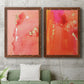 Set of two maple barnwood framed canvas prints depicting a coordinated art pair of luminous coral orange and pink color fields with gold flecks rendered as glamorous fluid abstracts above a sofa in a modern living room.
