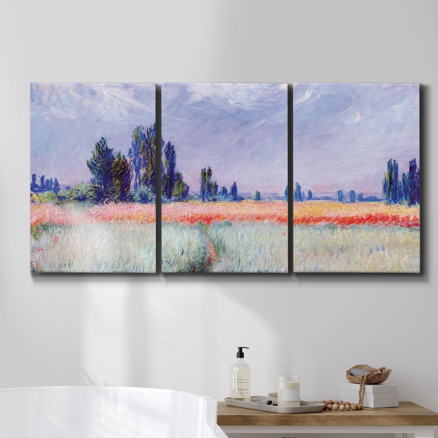 Three-panel canvas wall art featuring flowering field with poppies, displayed in a bathroom above a bathtub.