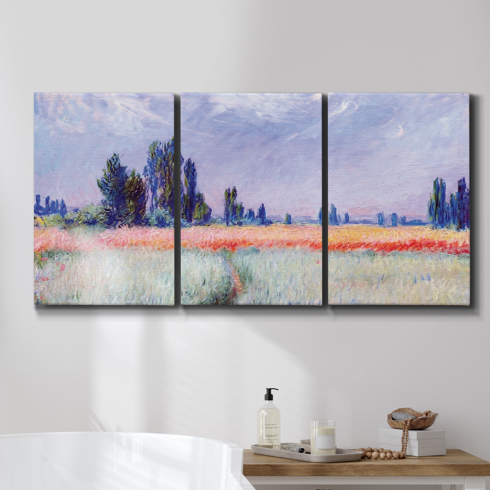 Three-panel canvas wall art featuring flowering field with poppies, displayed in a bathroom above a bathtub.