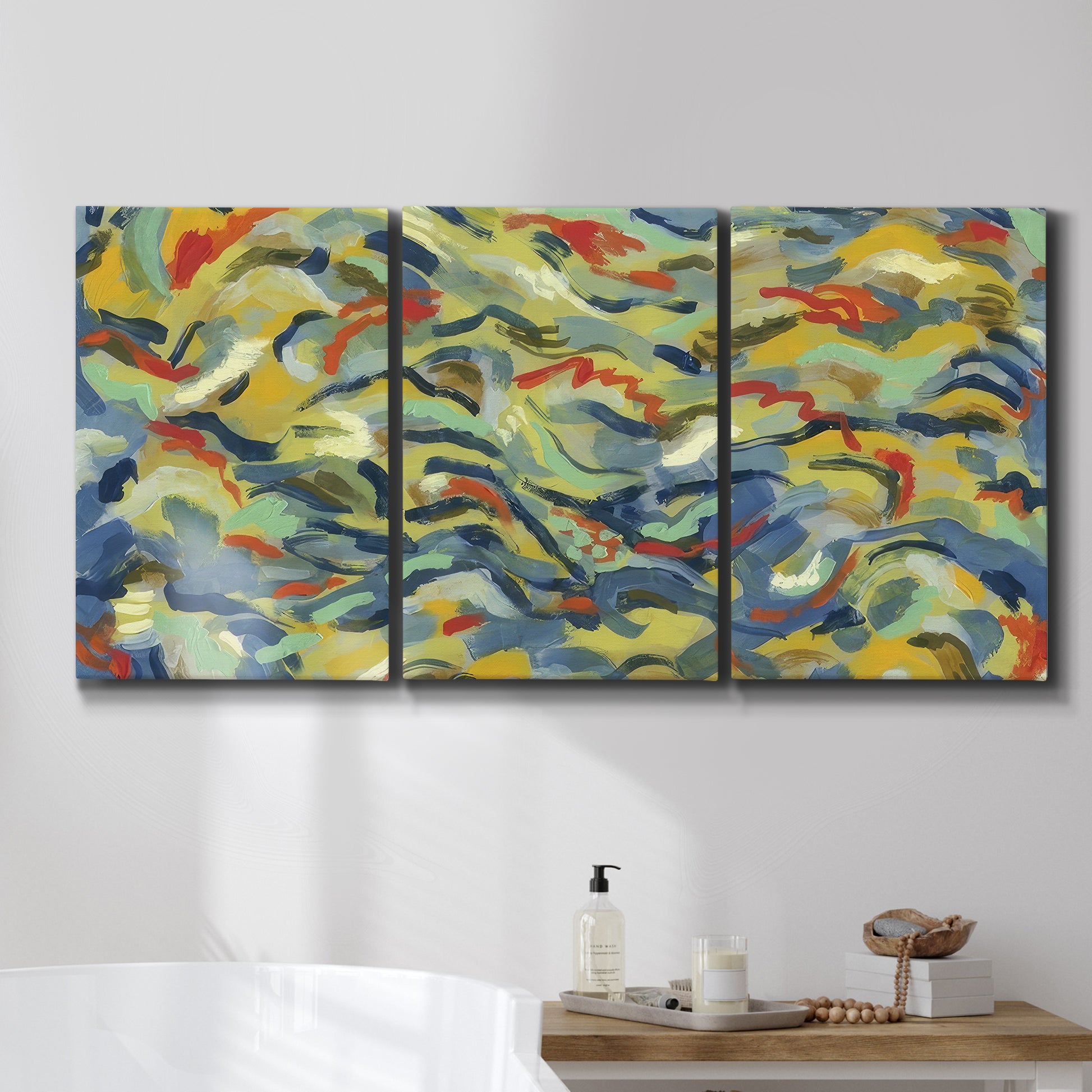 Three-panel canvas wall art featuring colorful abstract river like motion, displayed in a bathroom above a bathtub.