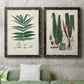 Set of two black barnwood framed canvas prints depicting a coordinated art pair of vintage fern specimens with botanical details rendered as natural-history fern plates above a sofa in a modern living room.