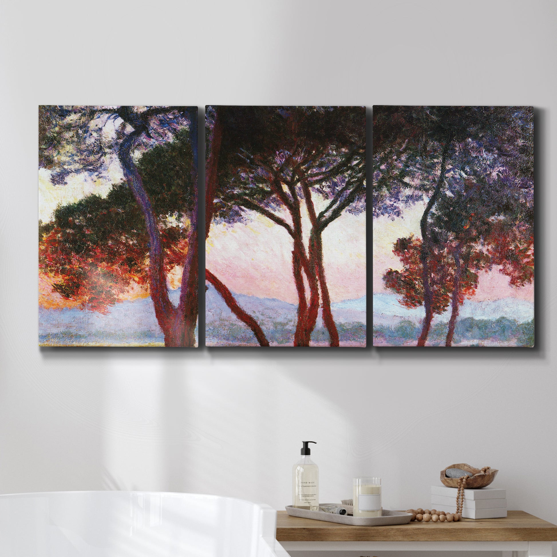 Three-panel canvas wall art featuring sunlit pines along mediterranean coast, displayed in a bathroom above a bathtub.