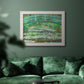 Impressionist garden scene with Japanese bridge and water lilies by Claude Monet in an ornate weathered white frame displayed in a dark-toned interior setting.
