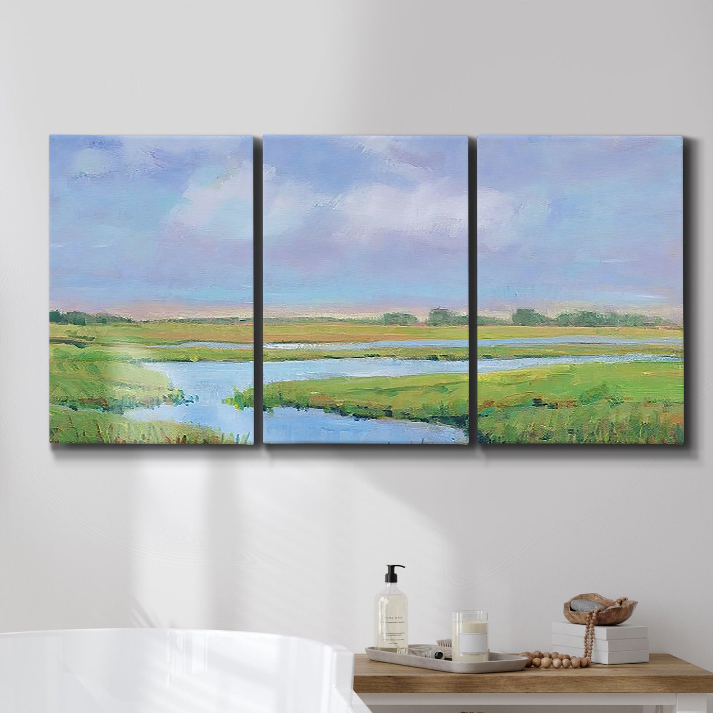 Three-panel canvas wall art featuring summer marshland with tall grasses, displayed in a bathroom above a bathtub.