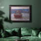 Impressionist single haystack landscape by Claude Monet in an ornate black frame with gilded inner detail displayed in a dark-toned interior setting.