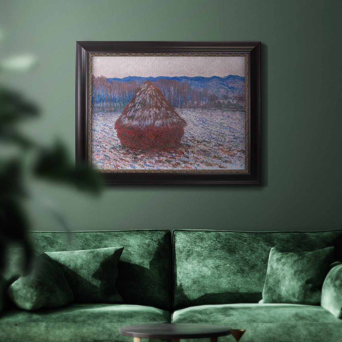 Impressionist single haystack landscape by Claude Monet in an ornate black frame with gilded inner detail displayed in a dark-toned interior setting.