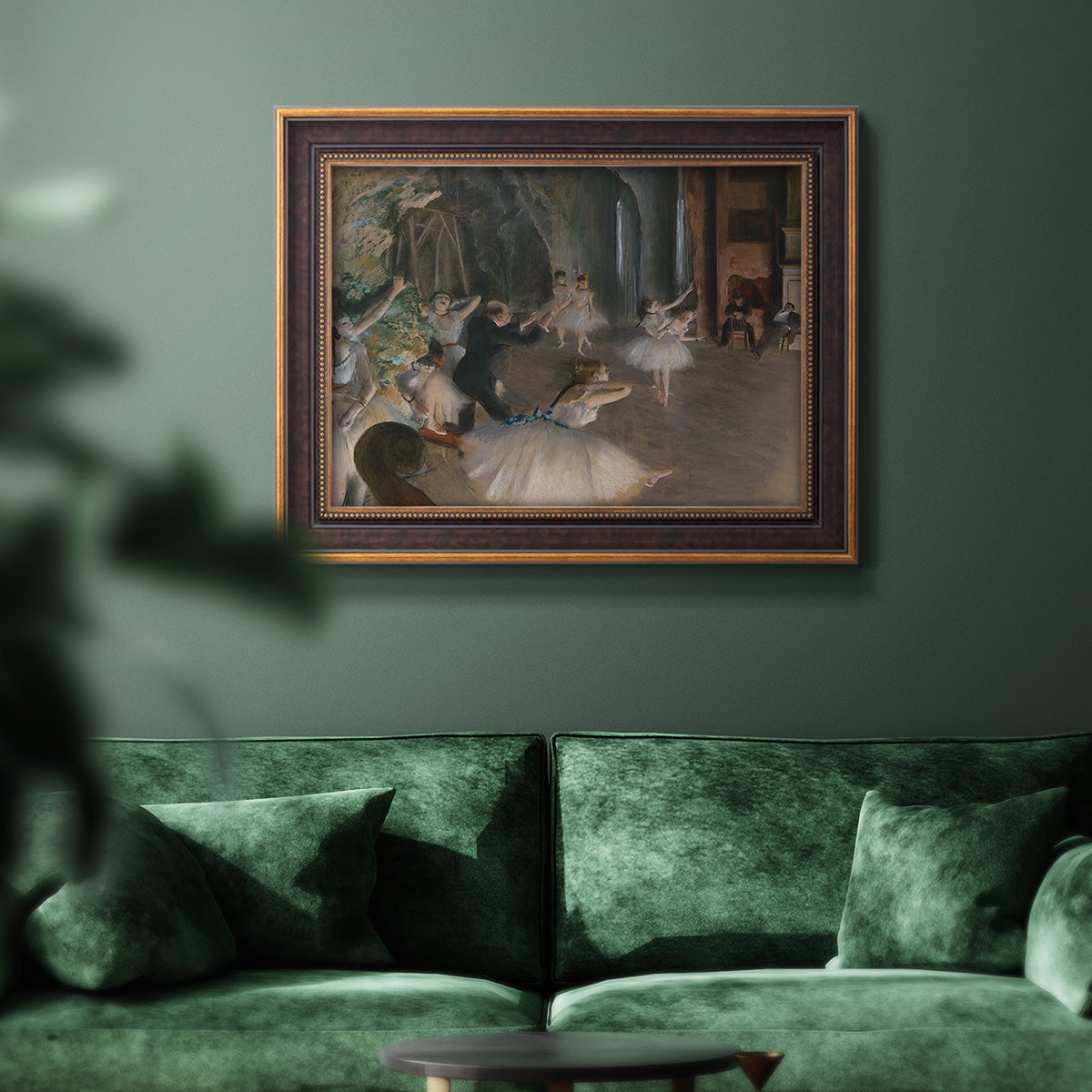 Impressionist backstage ballet scene by Edgar Degas in an ornate bronzed mahogany wood frame displayed in a dark-toned interior setting.