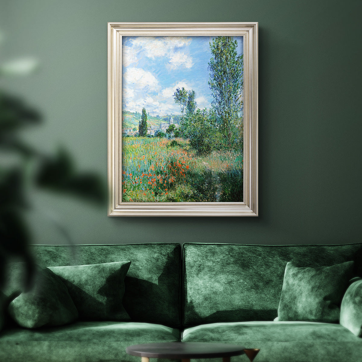 Impressionist pastoral landscape with poppy fields by Claude Monet in an ornate champagne frame displayed in a dark-toned interior setting.