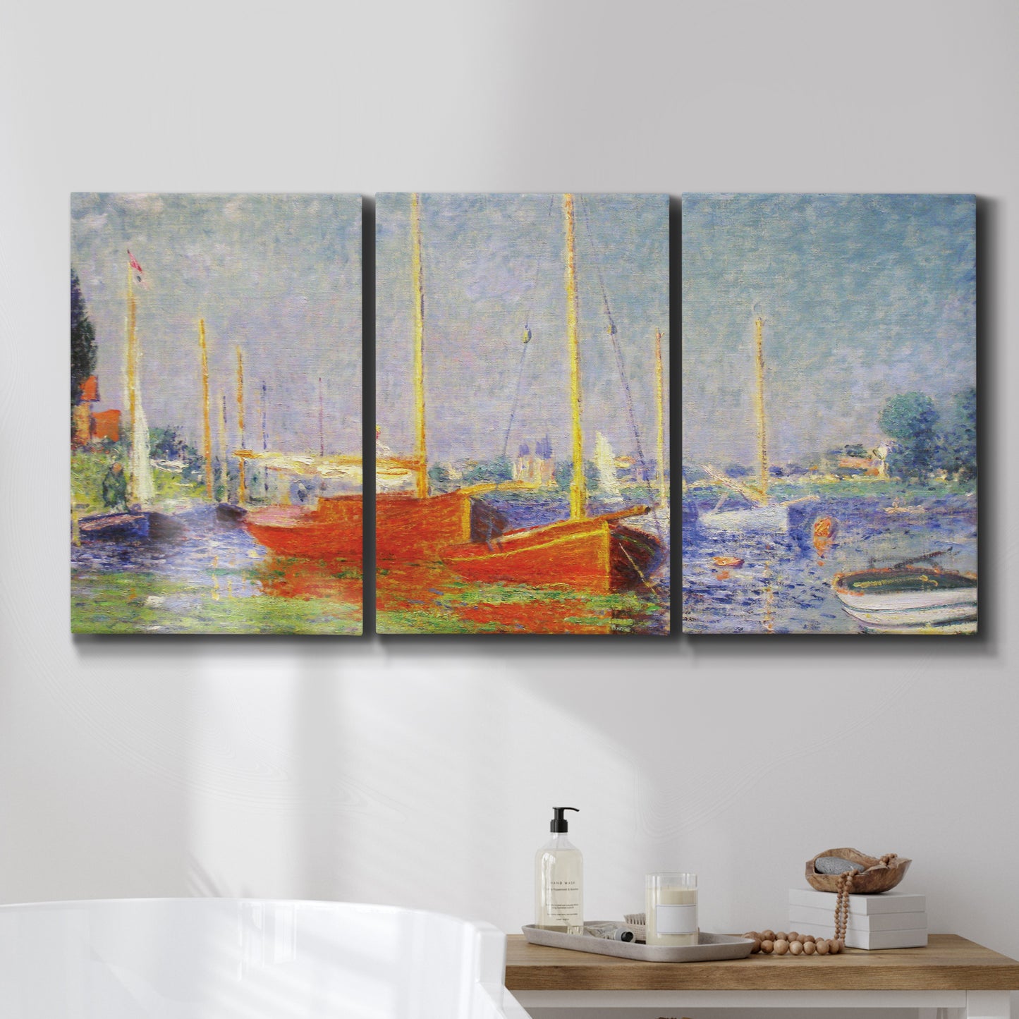 Three-panel canvas wall art featuring red boats along riverbank, displayed in a bathroom above a bathtub.