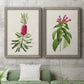 Set of two gray barnwood framed canvas prints depicting a coordinated art pair of pink flowering plant specimens rendered as vintage botanical plate illustrations above a sofa in a modern living room.