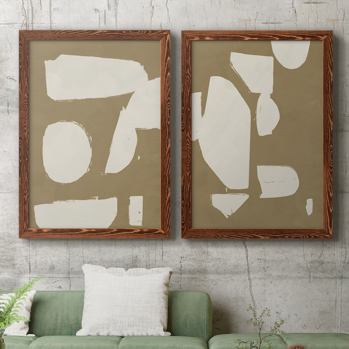 Set of two maple barnwood framed canvas prints depicting a coordinated art pair of irregular white cutout-like shapes on taupe grounds rendered as bold minimalist shape abstracts above a sofa in a modern living room.