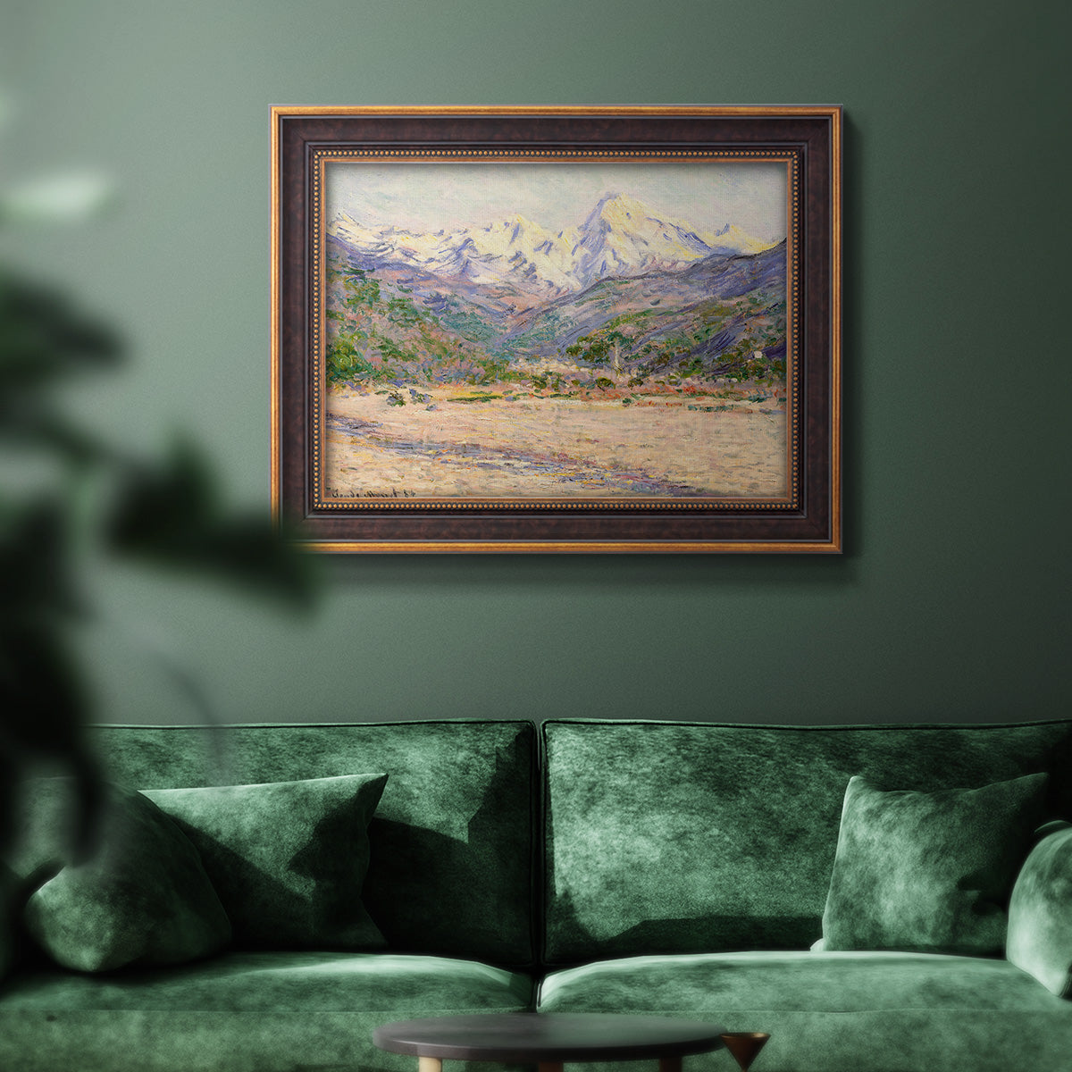 Impressionist valley landscape in southern France by Claude Monet in an ornate bronzed mahogany wood frame displayed in a dark-toned interior setting.