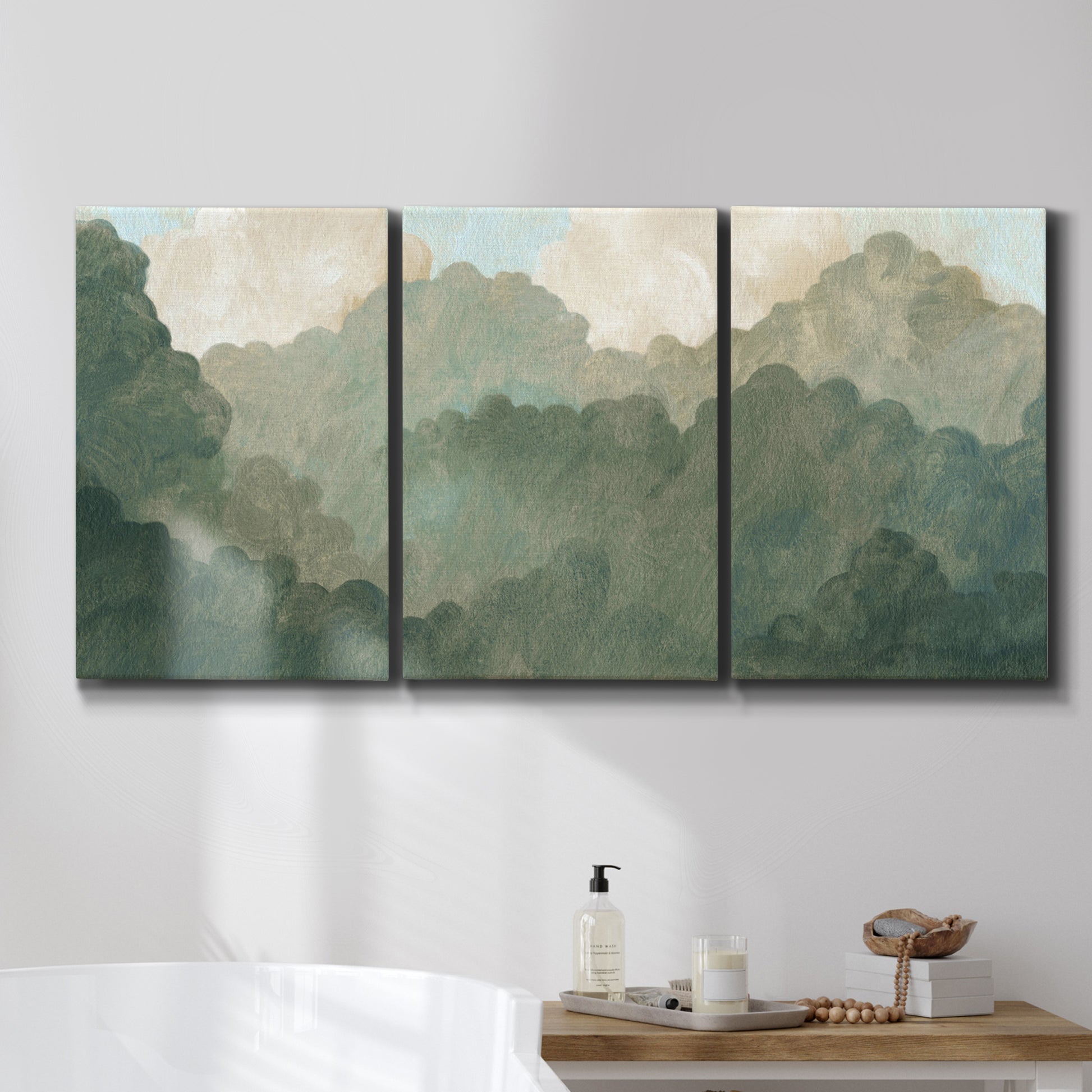 Three-panel canvas wall art featuring autumn storm over rolling landscape, displayed in a bathroom above a bathtub.