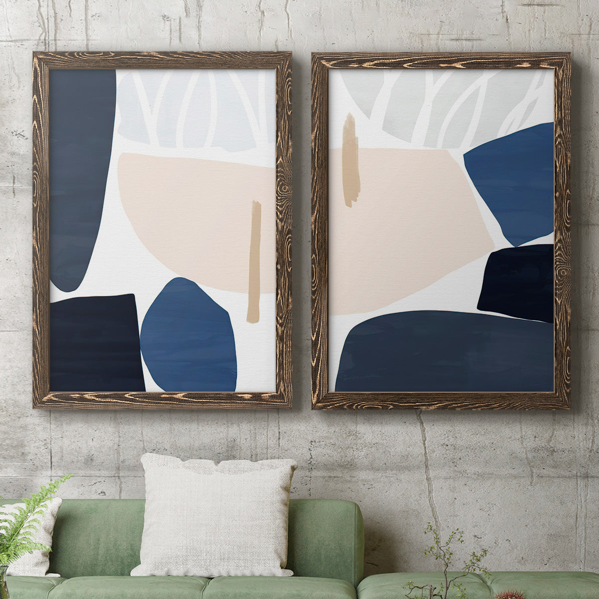 Set of two walnut barnwood framed canvas prints depicting a coordinated art pair of large navy cream and beige organic geometric shapes rendered as minimalist color-block abstracts above a sofa in a modern living room.