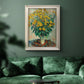 Impressionist floral painting of artichoke flowers by Claude Monet in an ornate champagne frame displayed in a dark-toned interior setting.