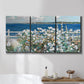 Three-panel canvas wall art featuring coastal garden overlooking bay, displayed in a bathroom above a bathtub.