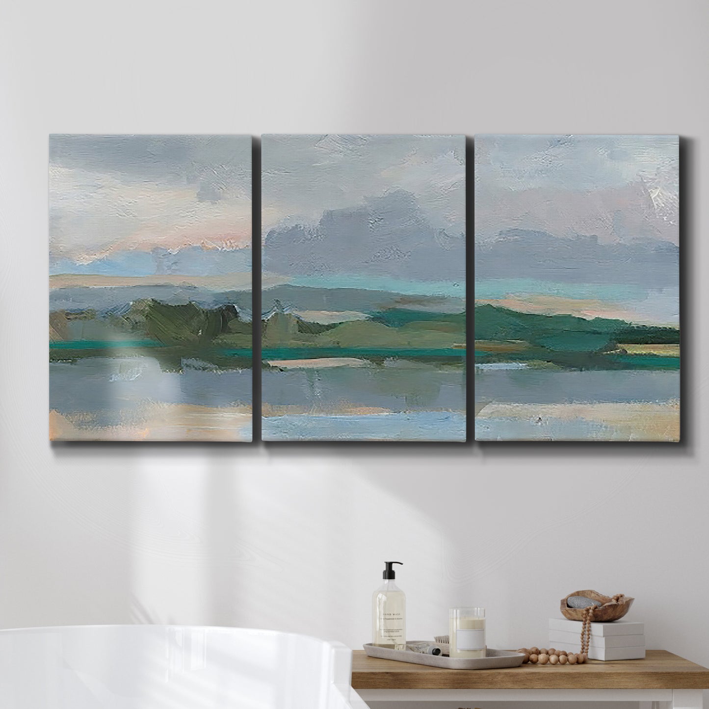 Three-panel canvas wall art featuring twilight landscape with fading light, displayed in a bathroom above a bathtub.