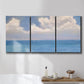 Three-panel canvas wall art featuring coastal shoreline with distant horizon, displayed in a bathroom above a bathtub.