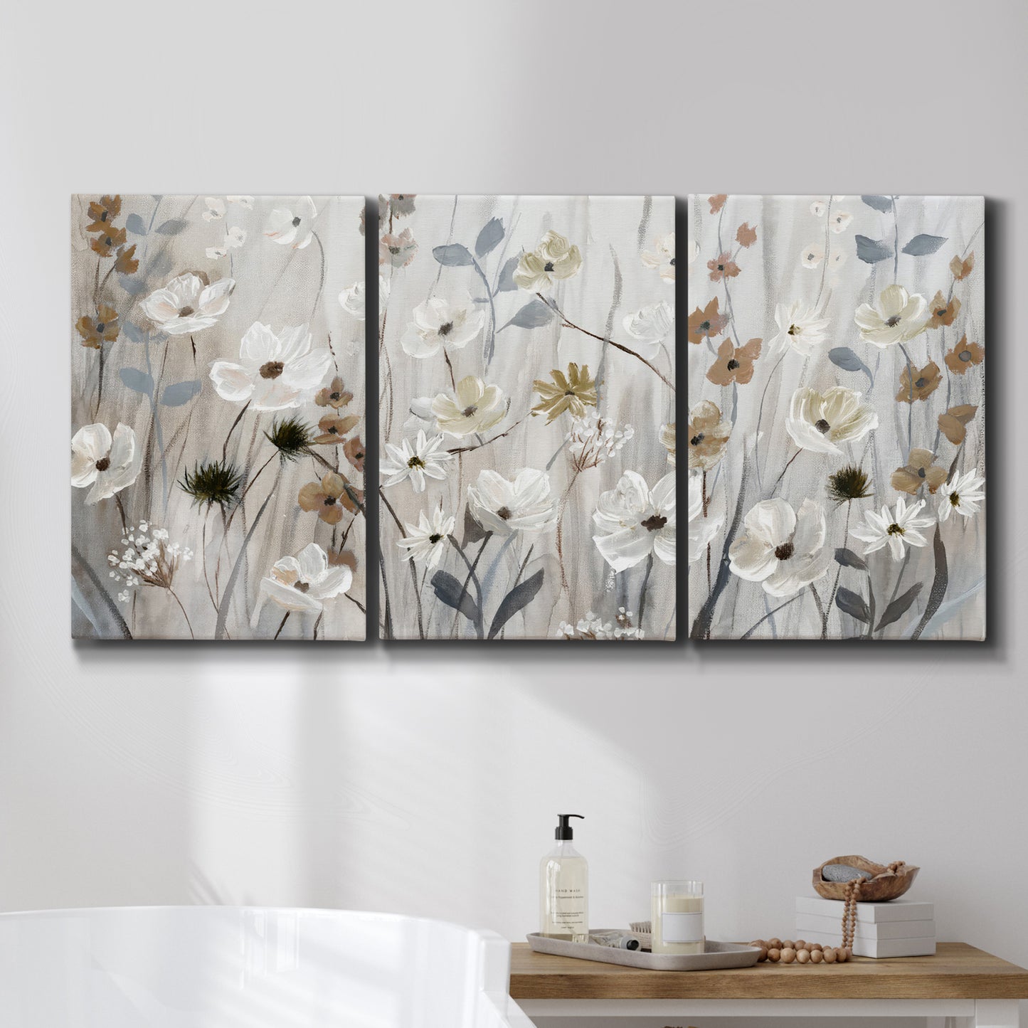 Three-panel canvas wall art featuring misty wildflower meadow landscape, displayed in a bathroom above a bathtub.