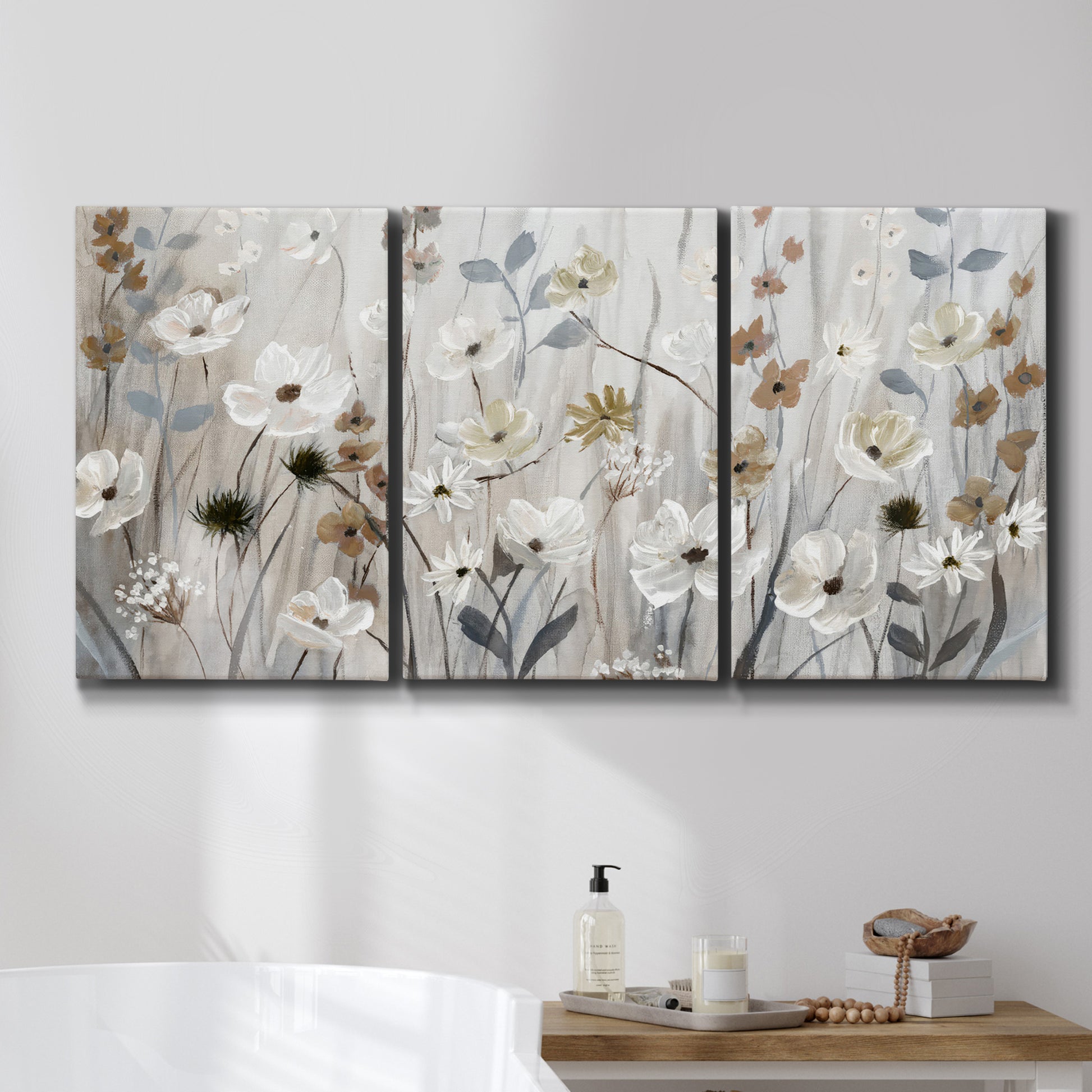 Three-panel canvas wall art featuring misty wildflower meadow landscape, displayed in a bathroom above a bathtub.