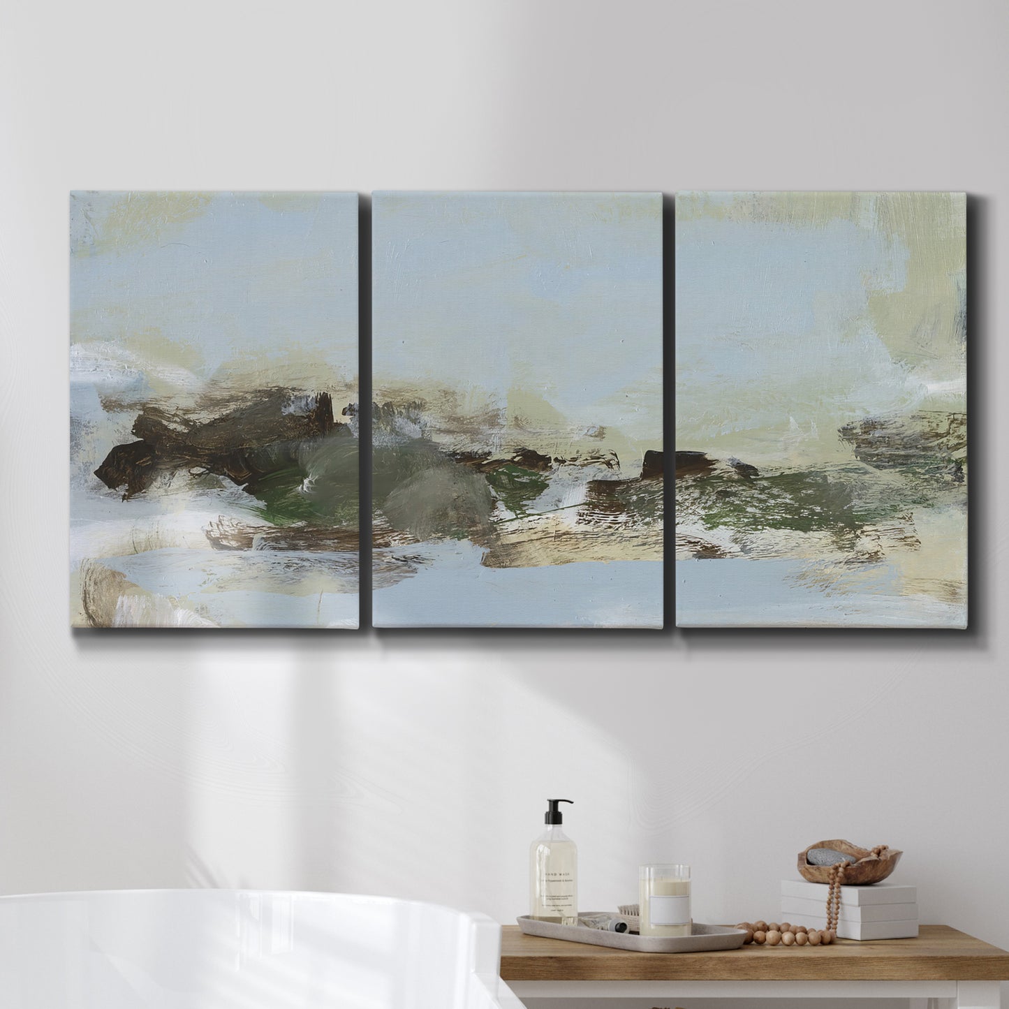 Three-panel canvas wall art featuring minimal abstract summer landscape, displayed in a bathroom above a bathtub.