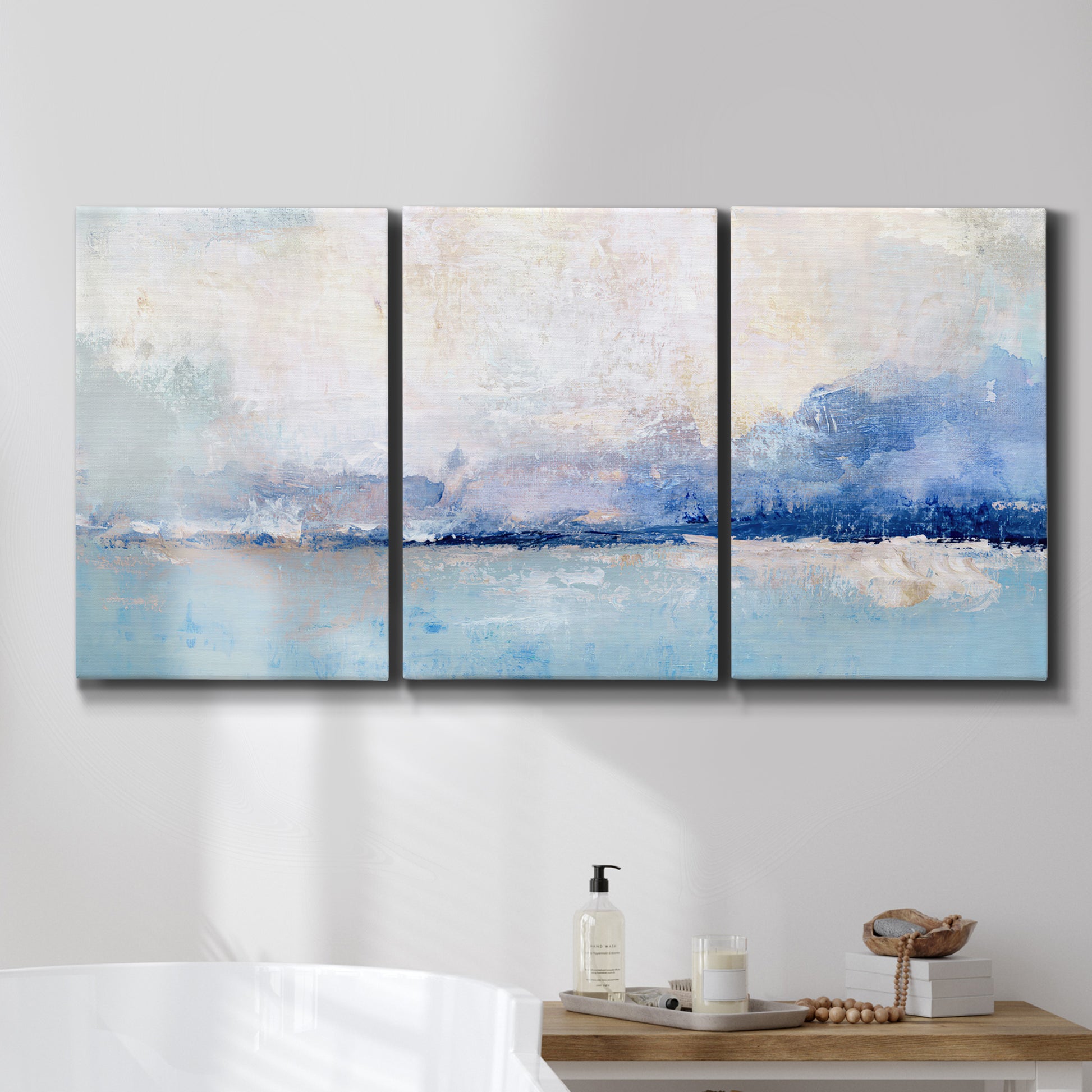 Three-panel canvas wall art featuring abstract bay with rhythmic forms, displayed in a bathroom above a bathtub.