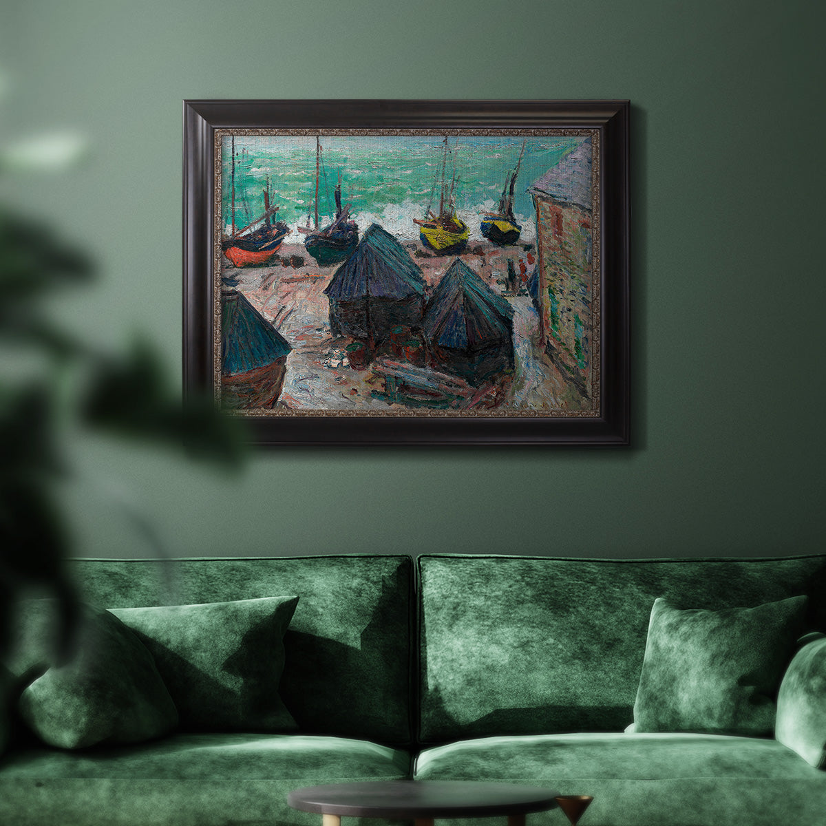 Impressionist coastal beach scene with boats by Claude Monet in an ornate black frame with gilded inner detail displayed in a dark-toned interior setting.