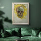 Expressive skull study painting by Vincent van Gogh in an ornate champagne frame displayed in a dark-toned interior setting.