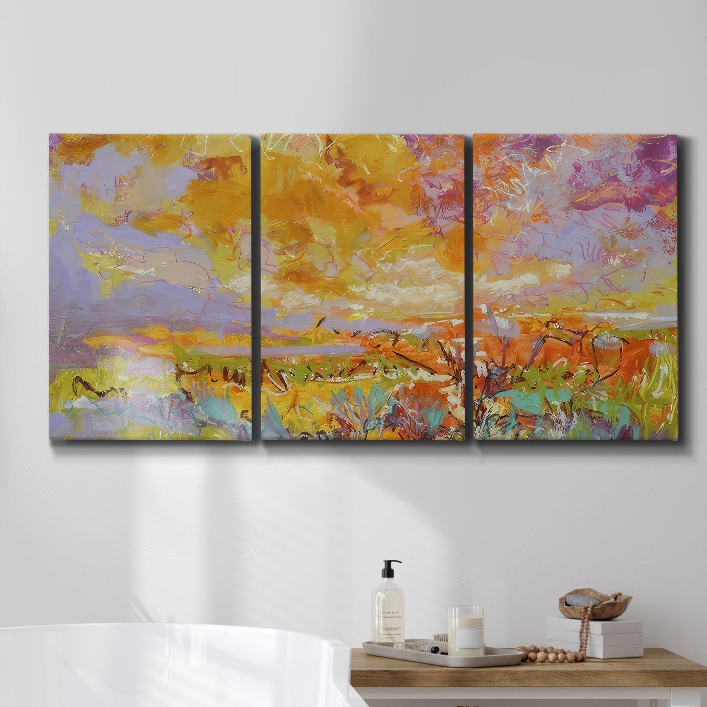 Three-panel canvas wall art featuring abstract meadow inspired color fields, displayed in a bathroom above a bathtub.