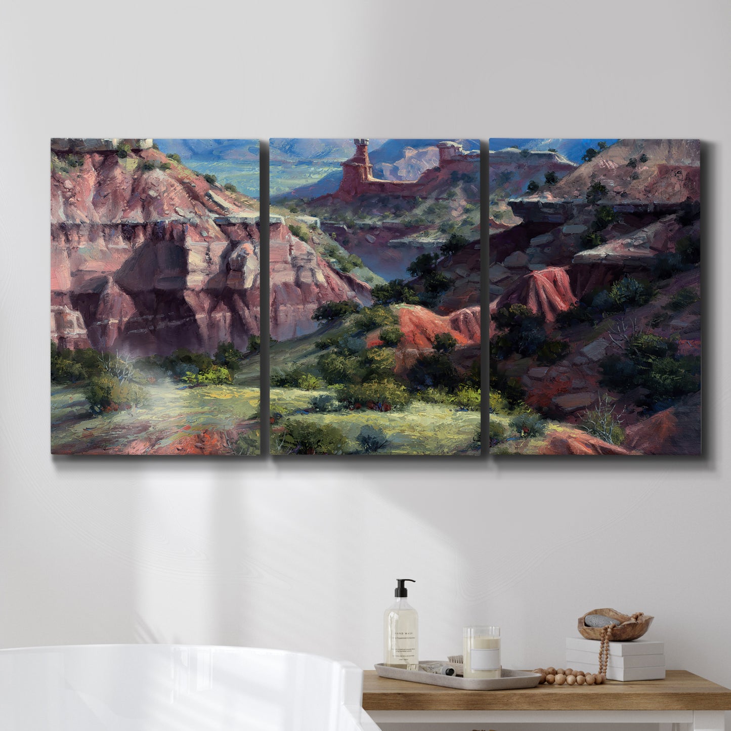 Three-panel canvas wall art featuring classic canyon landscape scene, displayed in a bathroom above a bathtub.