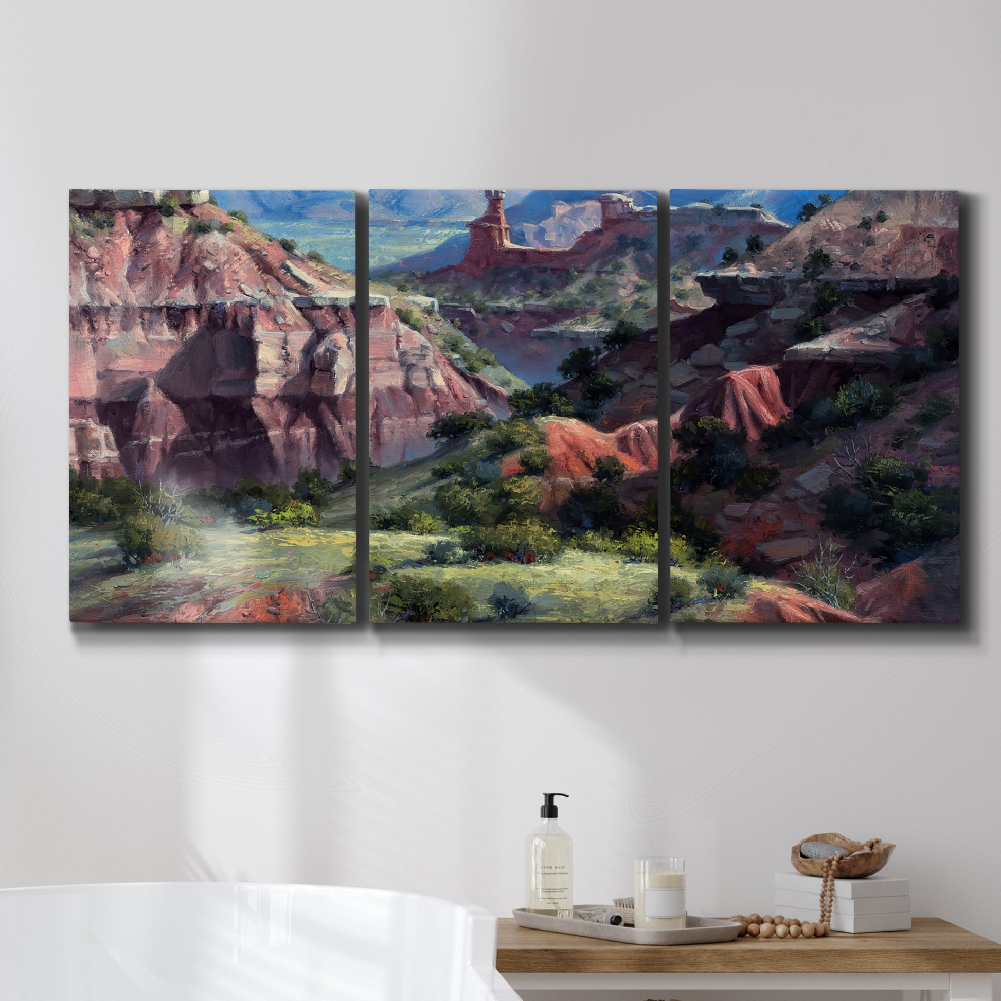 Three-panel canvas wall art featuring classic canyon landscape scene, displayed in a bathroom above a bathtub.