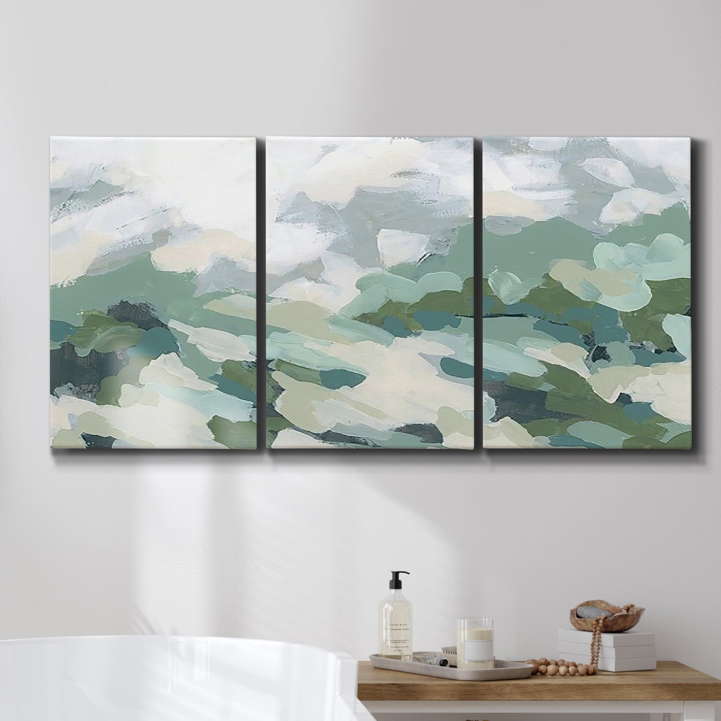 Three-panel canvas wall art featuring lush green hillside rolling landscape, displayed in a bathroom above a bathtub.