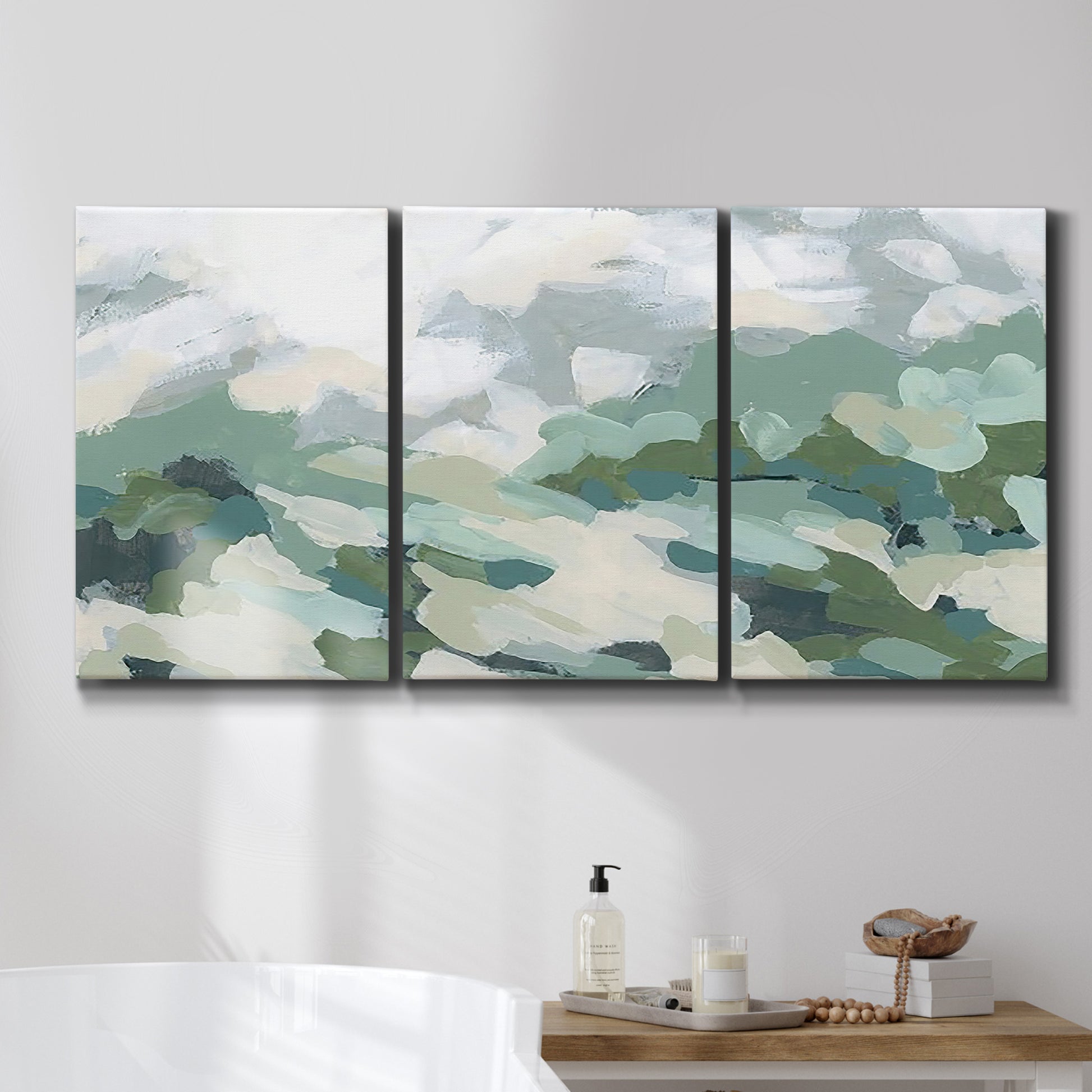 Three-panel canvas wall art featuring lush green hillside rolling landscape, displayed in a bathroom above a bathtub.
