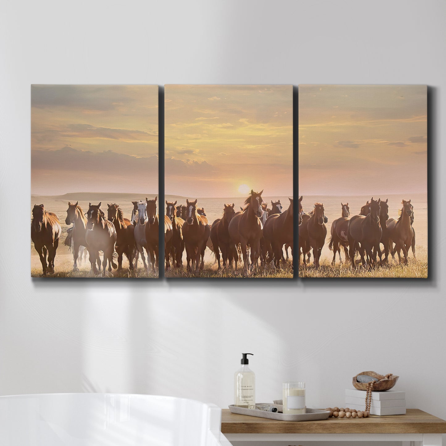Three-panel canvas wall art featuring running horses captured in motion, displayed in a bathroom above a bathtub.