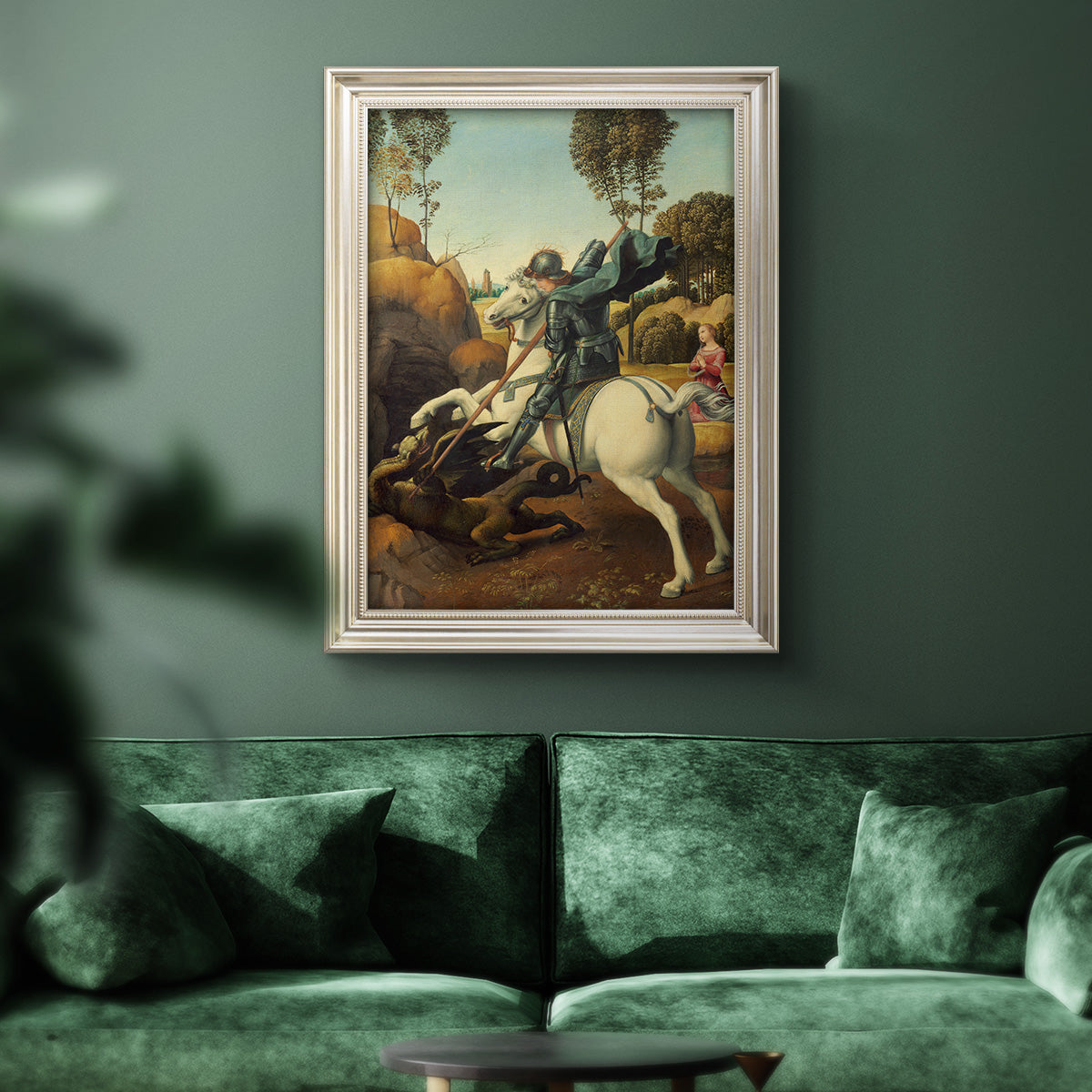 Religious painting of Saint George slaying the dragon by Raphael in an ornate champagne frame displayed in a dark-toned interior setting.