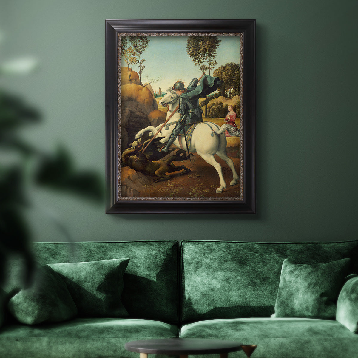 Religious painting of Saint George slaying the dragon by Raphael in an ornate black frame with gilded inner detail displayed in a dark-toned interior setting.