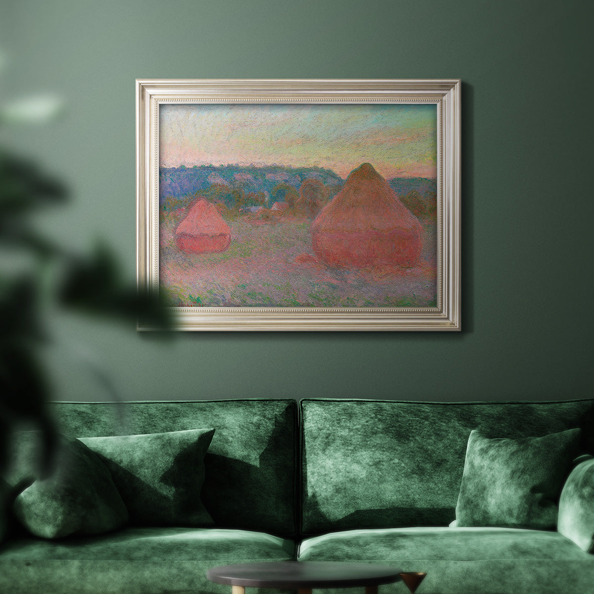 Impressionist haystack series landscape by Claude Monet in an ornate champagne frame displayed in a dark-toned interior setting.