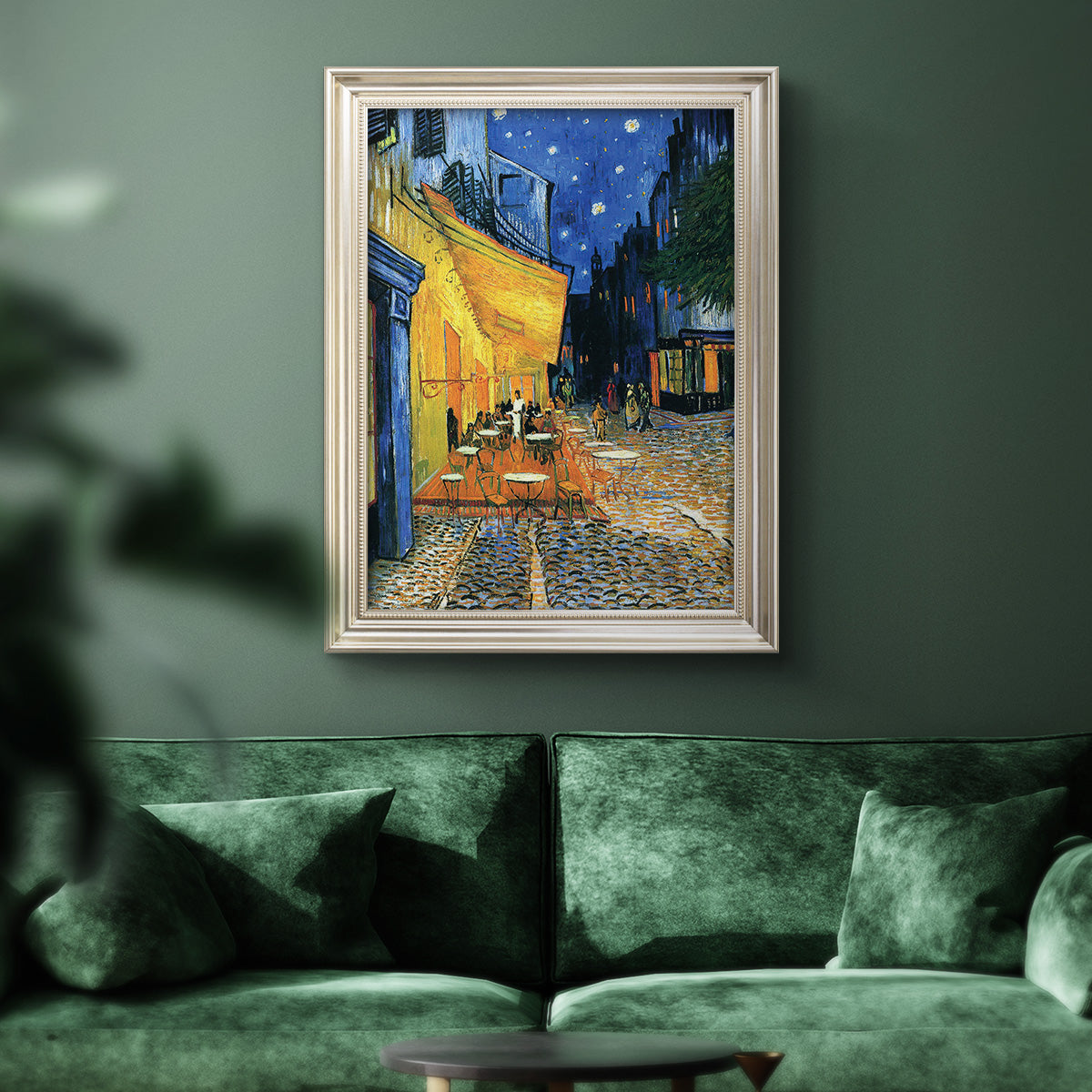 Impressionist night café street scene by Vincent van Gogh in an ornate champagne frame displayed in a dark-toned interior setting.