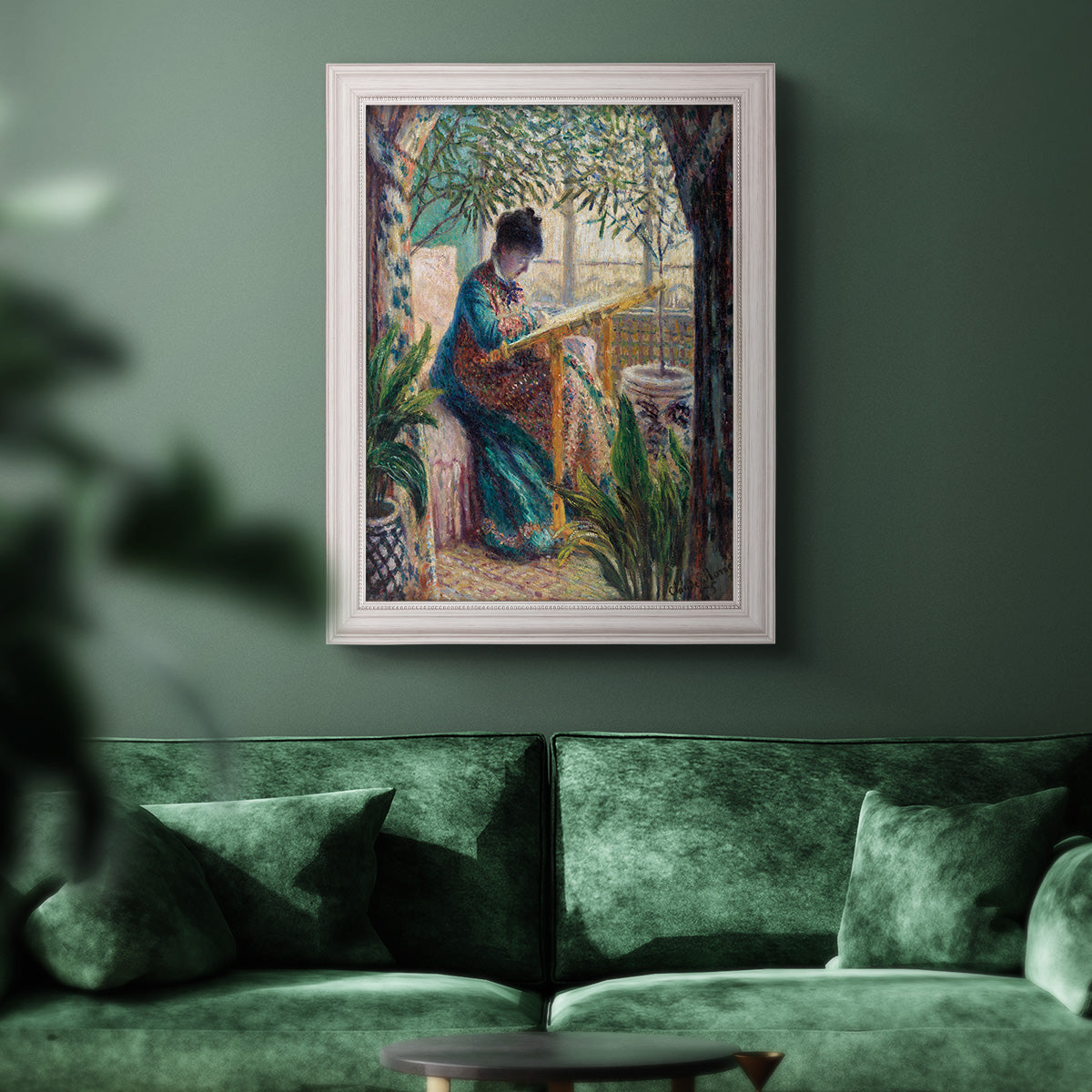Impressionist portrait of Madame Monet sewing by Claude Monet in an ornate weathered white frame displayed in a dark-toned interior setting.