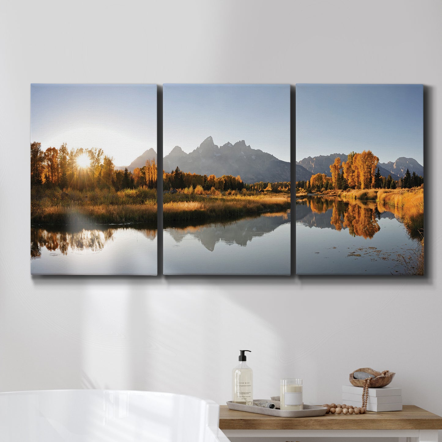 Three-panel canvas wall art featuring river canyon landscape photograph, displayed in a bathroom above a bathtub.
