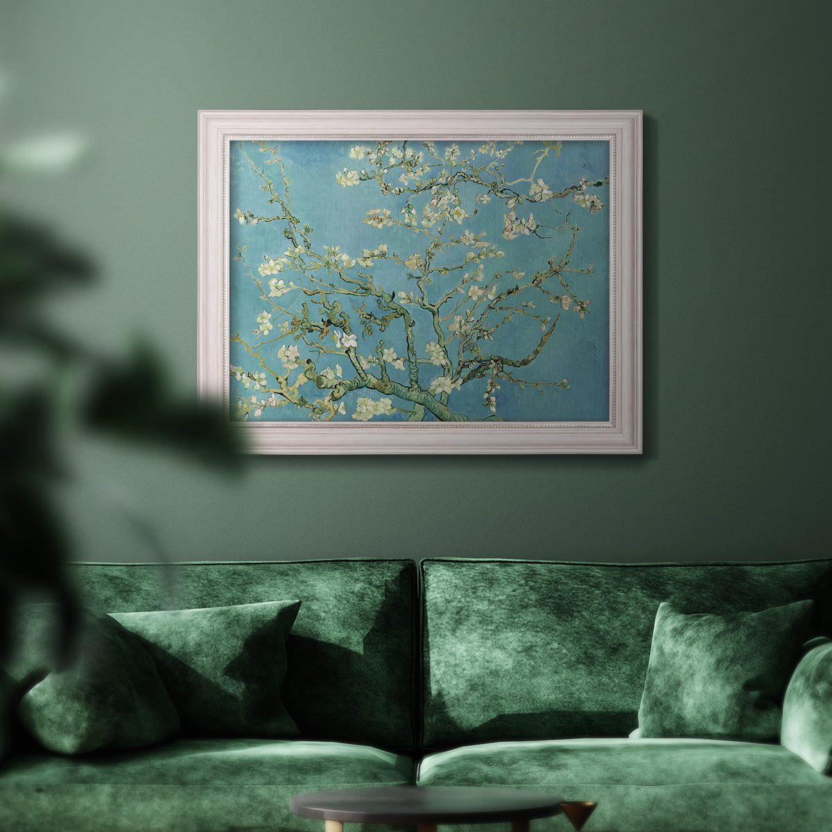 Impressionist flowering almond branch painting by Vincent van Gogh in an ornate weathered white frame displayed in a dark-toned interior setting.
