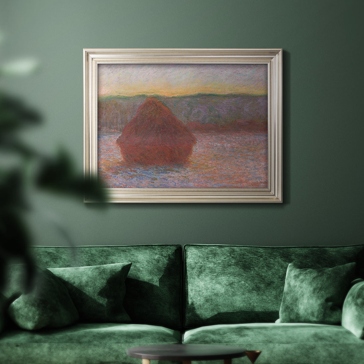Impressionist haystack sunset scene in winter by Claude Monet in an ornate champagne frame displayed in a dark-toned interior setting.