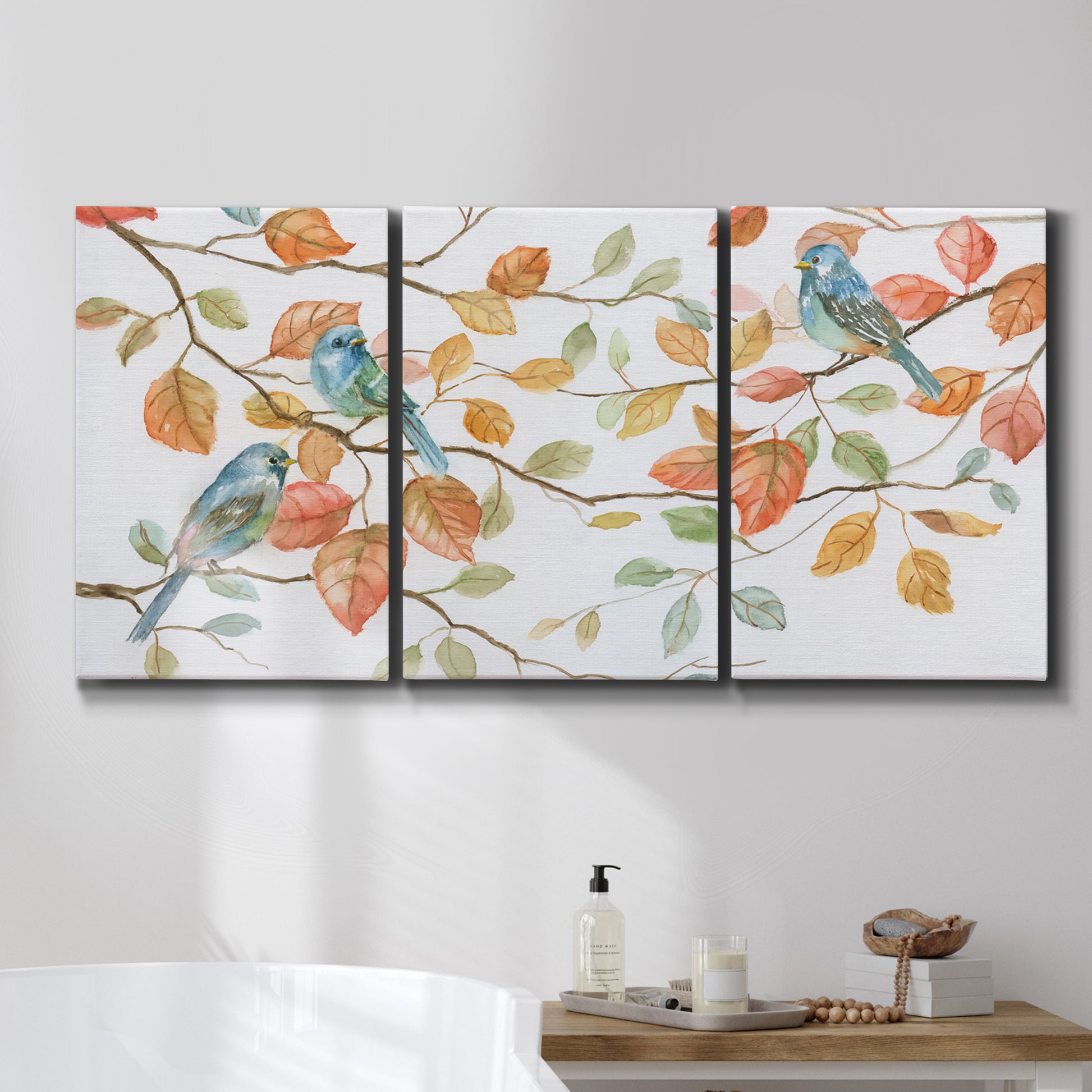 Three-panel canvas wall art featuring decorative bird trio illustration, displayed in a bathroom above a bathtub.