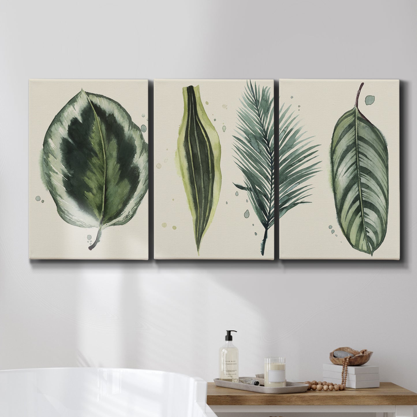 Three-panel canvas wall art featuring botanical palm leaf illustration, displayed in a bathroom above a bathtub.