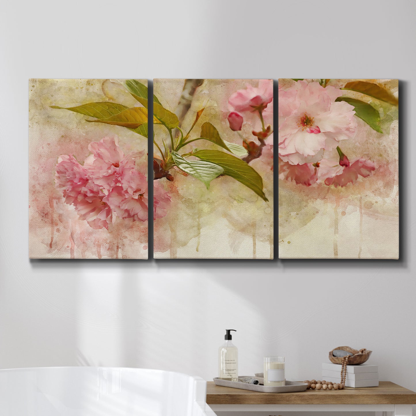 Three-panel canvas wall art featuring soft floral blossom composition, displayed in a bathroom above a bathtub.